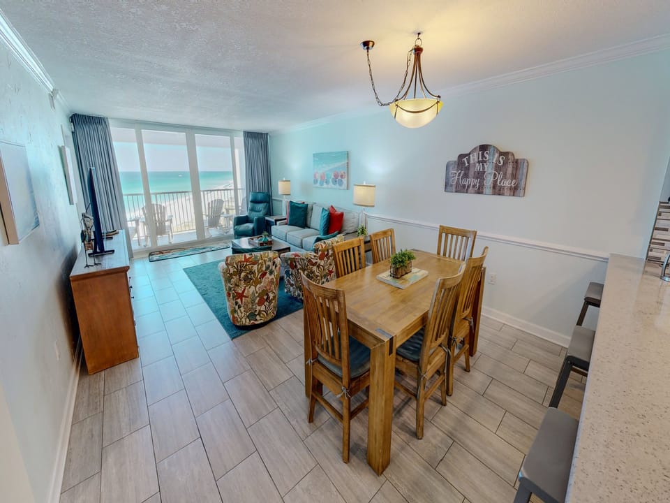 Gather around your spacious dining table with ocean views streaming through floor-to-ceiling windows, creating the perfect setting for memorable beachside meals.