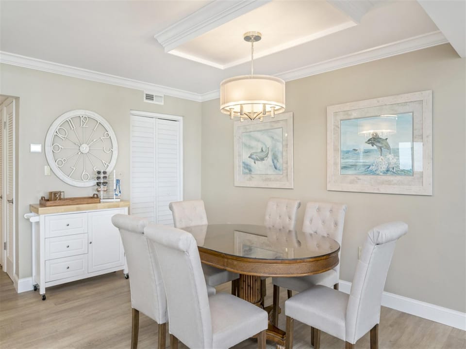 You'll love gathering around this elegant dining table with plush seating for eight, beneath sophisticated coastal artwork and warm lighting.