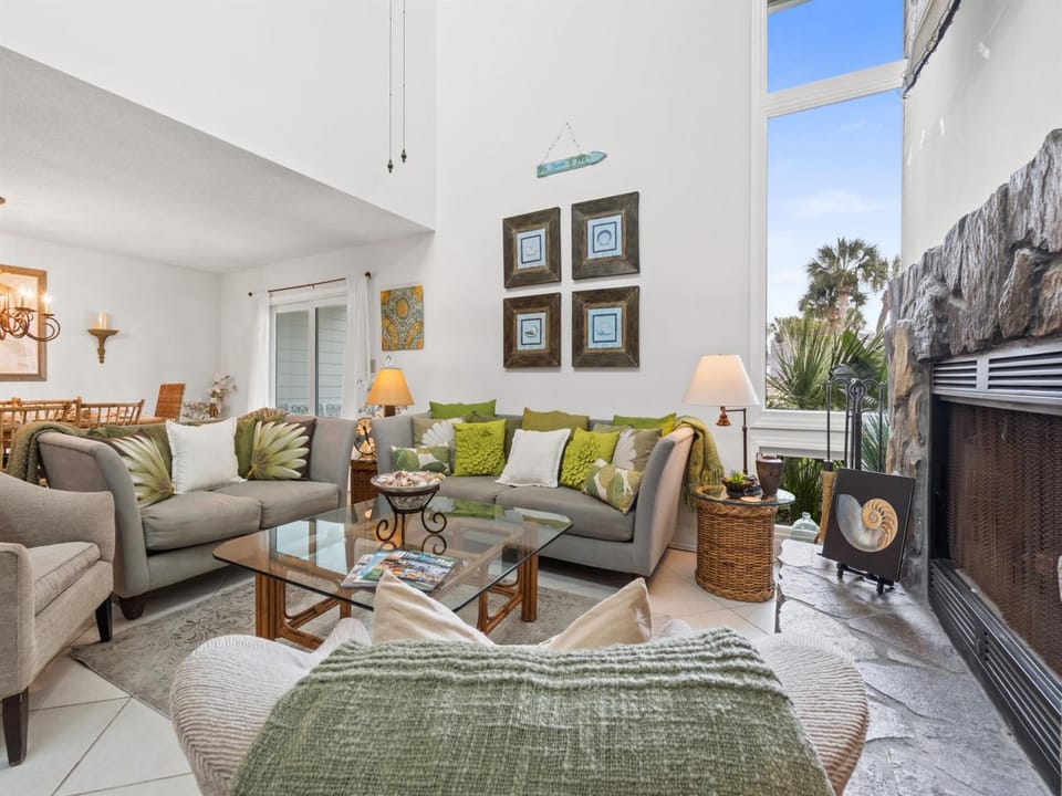 Unwind in your elegant living room with comfortable seating, warm fireplace, and stunning mountain views through floor-to-ceiling windows.