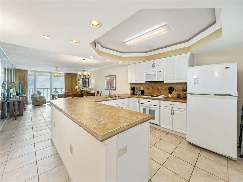 Cook with confidence in your spacious kitchen featuring granite counters and modern appliances, with stunning ocean views as your backdrop.
