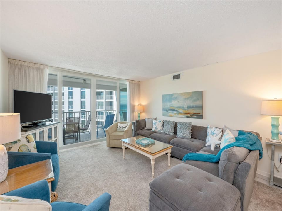 Unwind in this bright living space featuring a plush sectional sofa and coastal décor that creates your perfect retreat atmosphere.