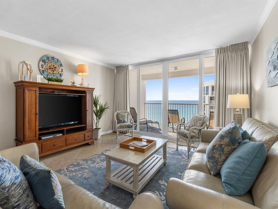 Sink into plush coastal furnishings while your private balcony frames endless ocean views through floor-to-ceiling windows.