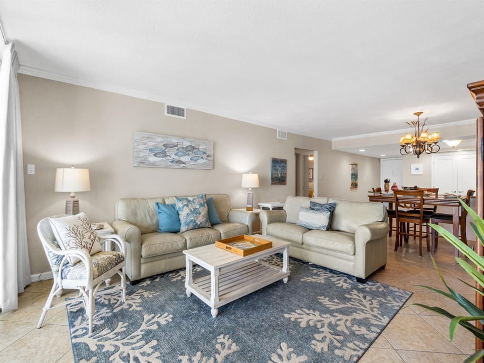 Sink into plush sofas in your spacious living room, where coastal blues and whites create a serene atmosphere for relaxing after beach adventures.
