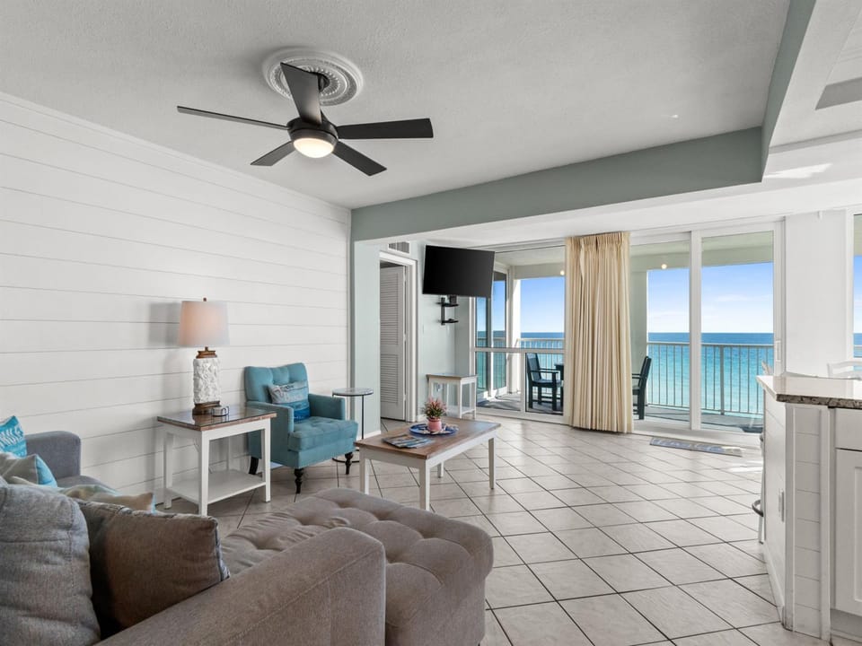 Relax in your bright oceanfront living room where coastal comfort meets stunning sea views through floor-to-ceiling windows.