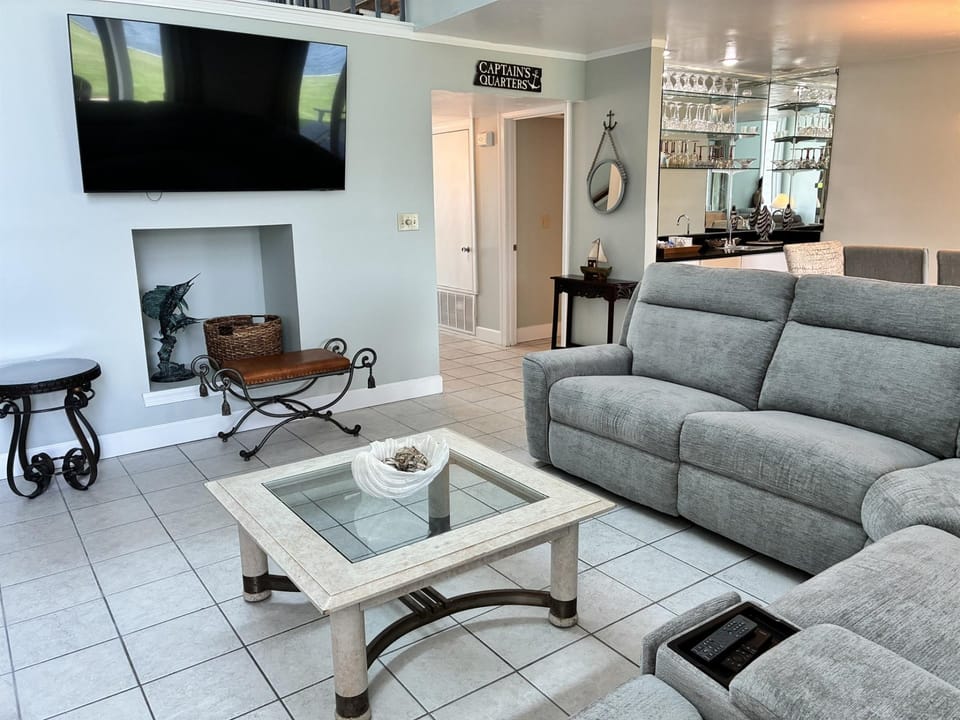 Your nautical-themed retreat features plush seating, a large flat-screen TV, and a warm fireplace for cozy evenings.