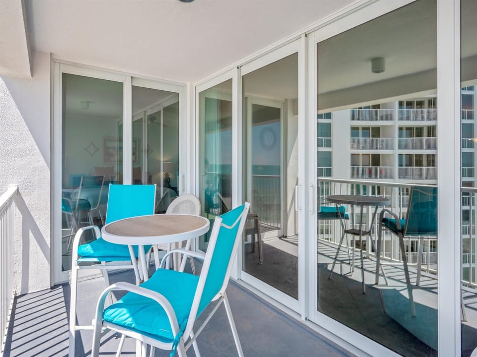 Step onto your private balcony with turquoise seating and enjoy morning coffee while taking in views of neighboring buildings.