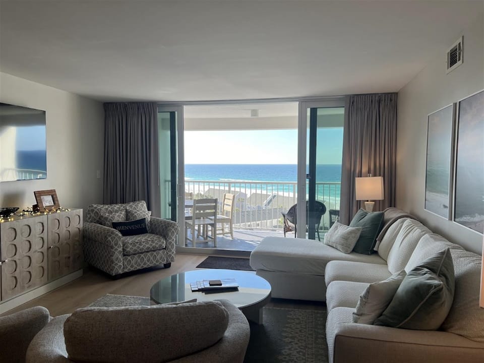 Sink into your comfortable living room where stunning ocean views await through floor-to-ceiling windows, creating the perfect backdrop for relaxation.