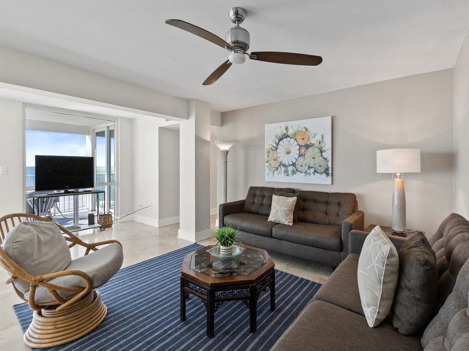 Relax in your stylish living room with ocean views, comfortable seating, and gentle ceiling fan breezes.