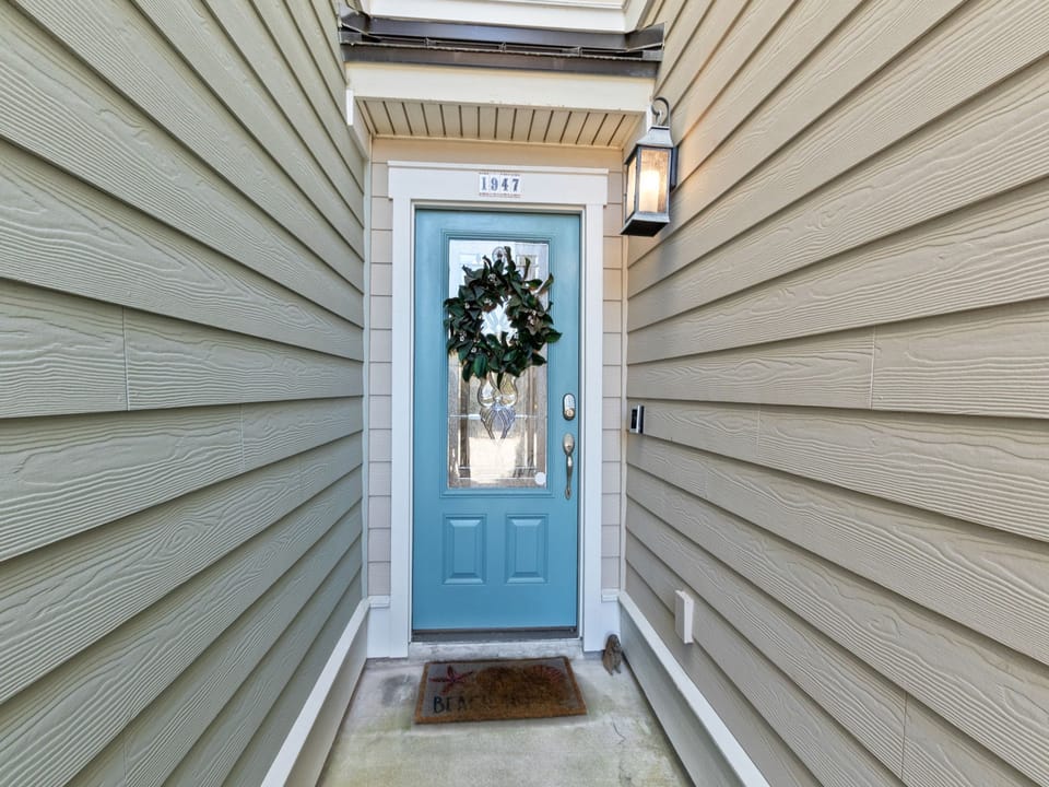 Charming entrance with blue door and welcoming wreath marks the arrival at this cozy retreat.