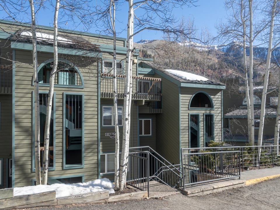 Mountain retreat surrounded by aspens and snow-capped peaks, offering a peaceful escape with scenic alpine views.