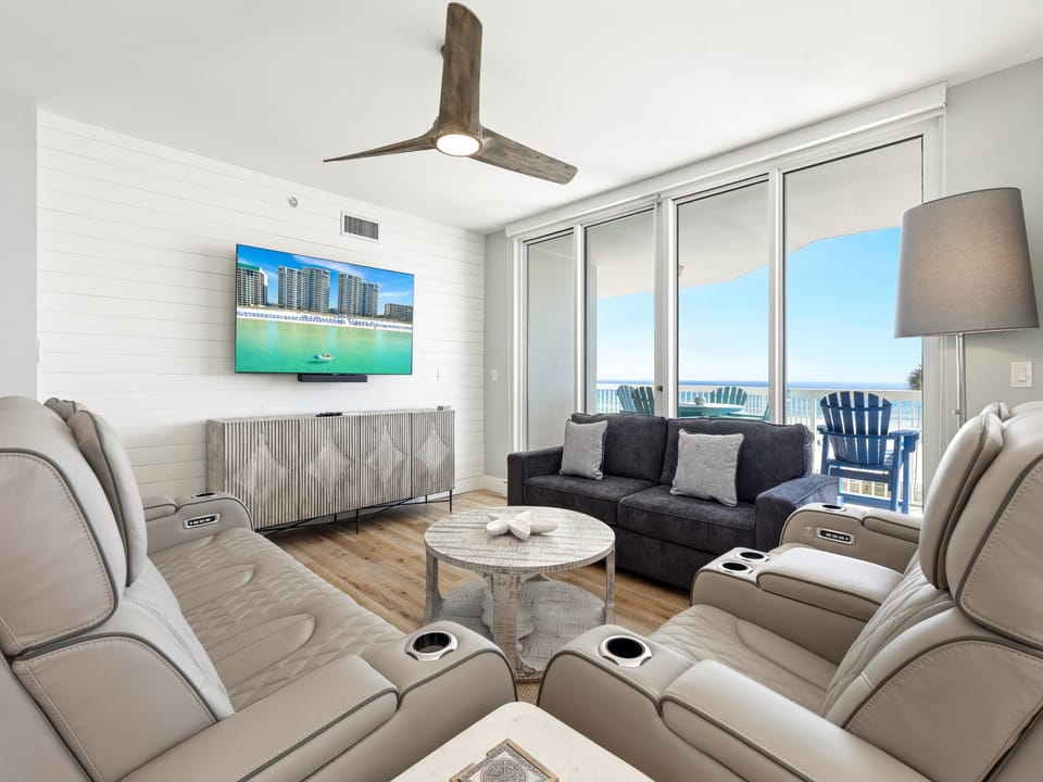 Sink into plush recliners and watch ocean views unfold through floor-to-ceiling windows in your bright, modern living space.