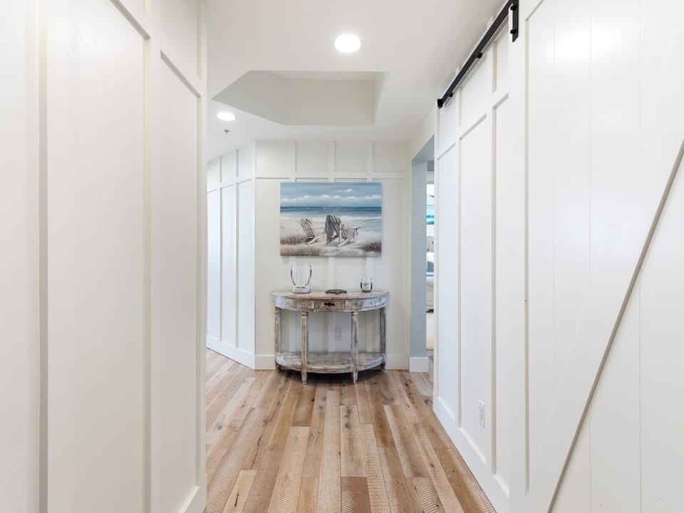 Step into your welcoming foyer where coastal art and warm wood floors create an instant sense of home and relaxation.