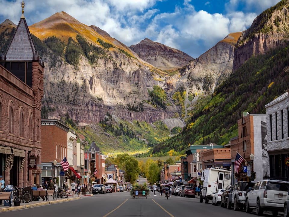 Historic mountain town with Victorian architecture nestled in a dramatic alpine valley setting.