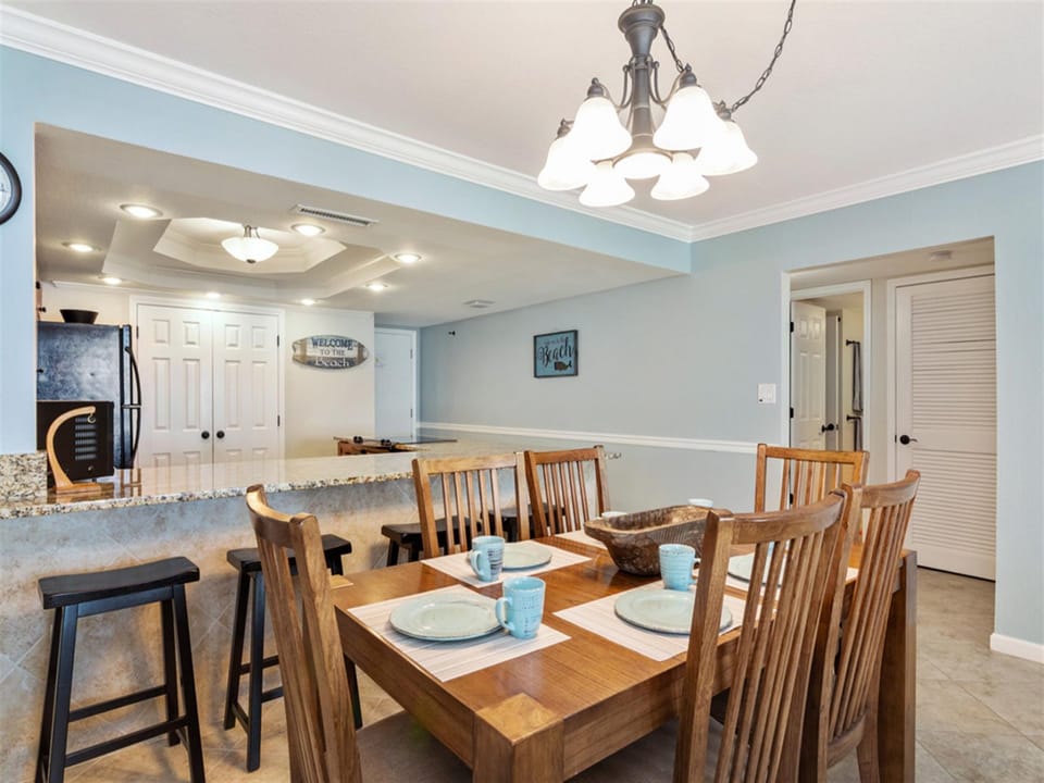 Gather around your spacious dining table where warm wood and soft blue walls create the perfect backdrop for memorable meals together.