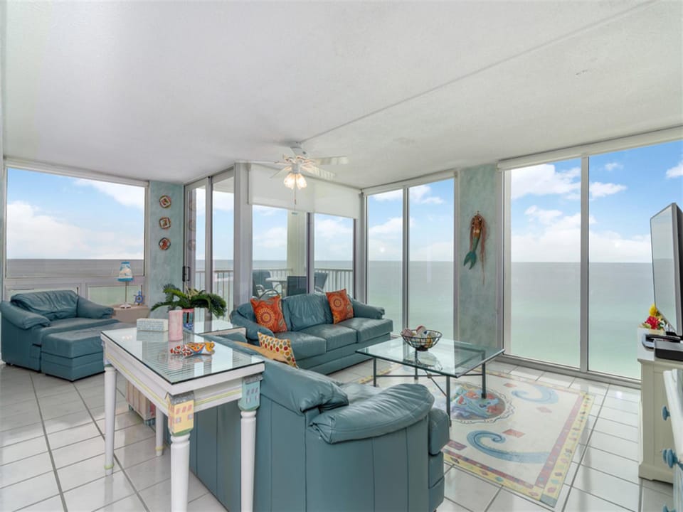 Relax in your oceanfront living room where floor-to-ceiling windows frame endless sea views. Sink into comfortable seating while watching waves from your private retreat.