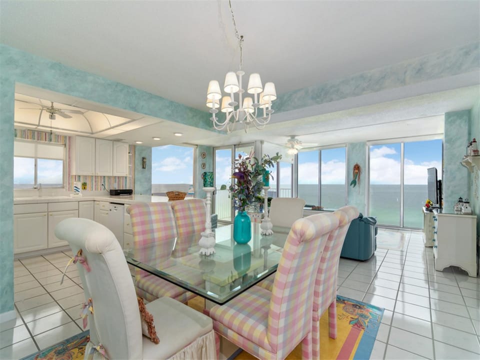 Enjoy breathtaking ocean views while dining in your elegant space with glass table and designer chandelier.