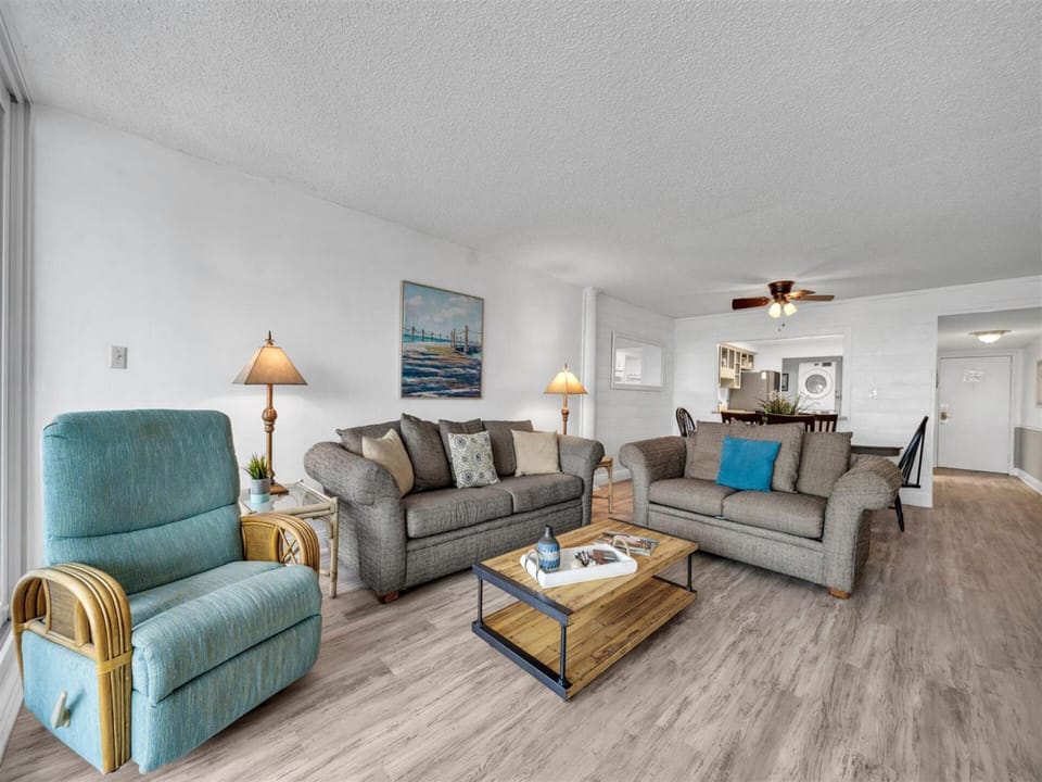 Settle into this spacious living room where coastal colors and comfy seating create your perfect retreat for relaxation.