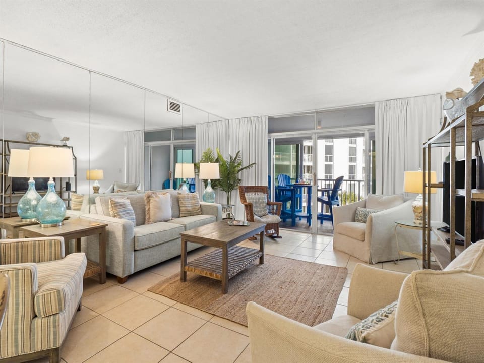 Sink into plush coastal seating in your bright, airy living room where natural light and beach-inspired decor create the perfect vacation ambiance.