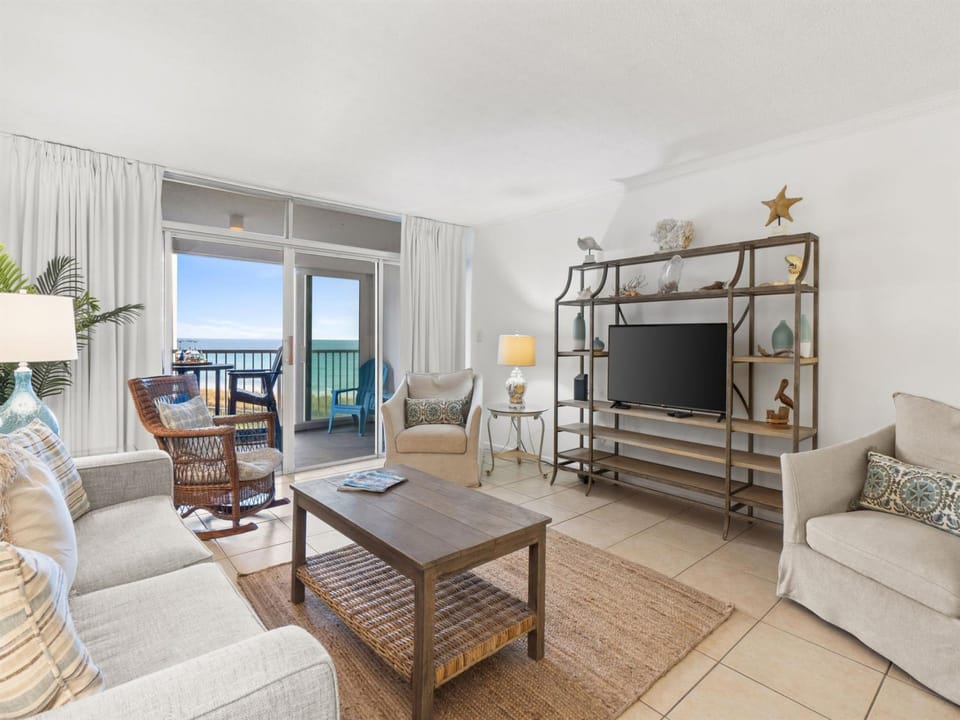 Relax in your coastal living room with comfortable seating and stunning ocean views from your private balcony.