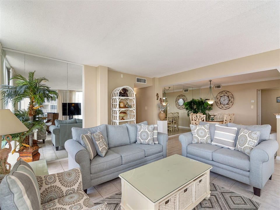 Unwind in your spacious living room with soft blue sofas, coastal décor, and gentle natural light streaming through.