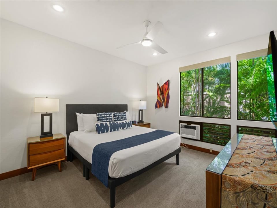 Spacious primary suite with a California king bed and serene garden views