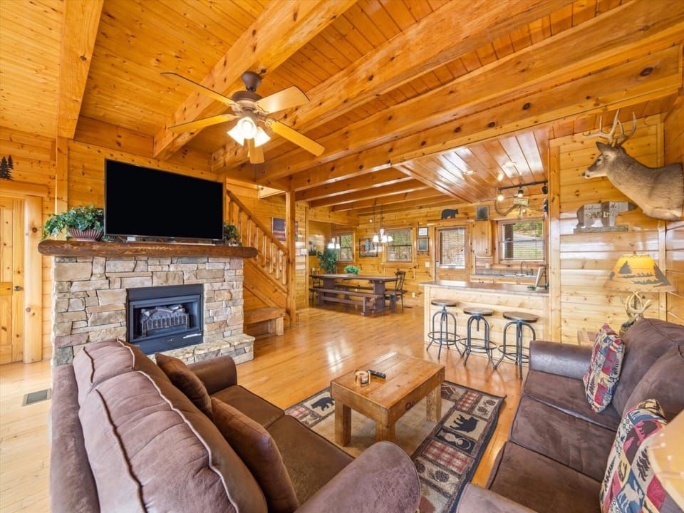 Sink into plush leather seating by the stone fireplace, where rustic charm meets modern comfort in your cozy mountain retreat.