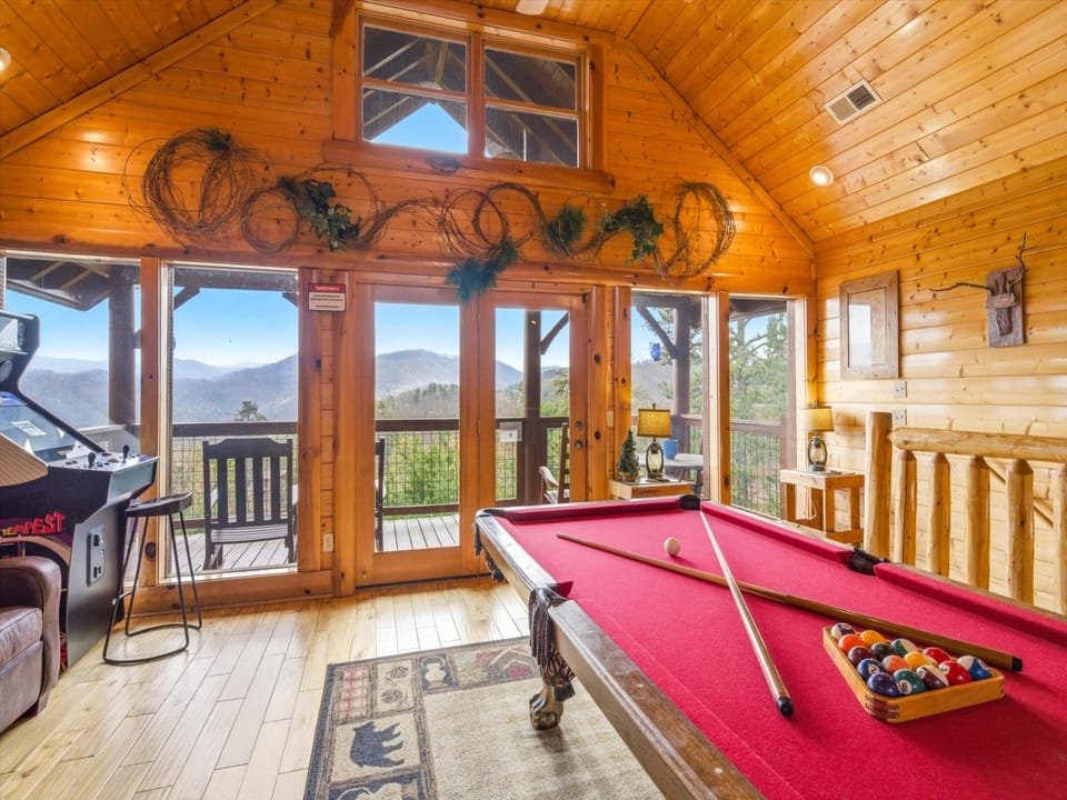 Your game room awaits with stunning mountain views, featuring a pool table and arcade for endless entertainment.