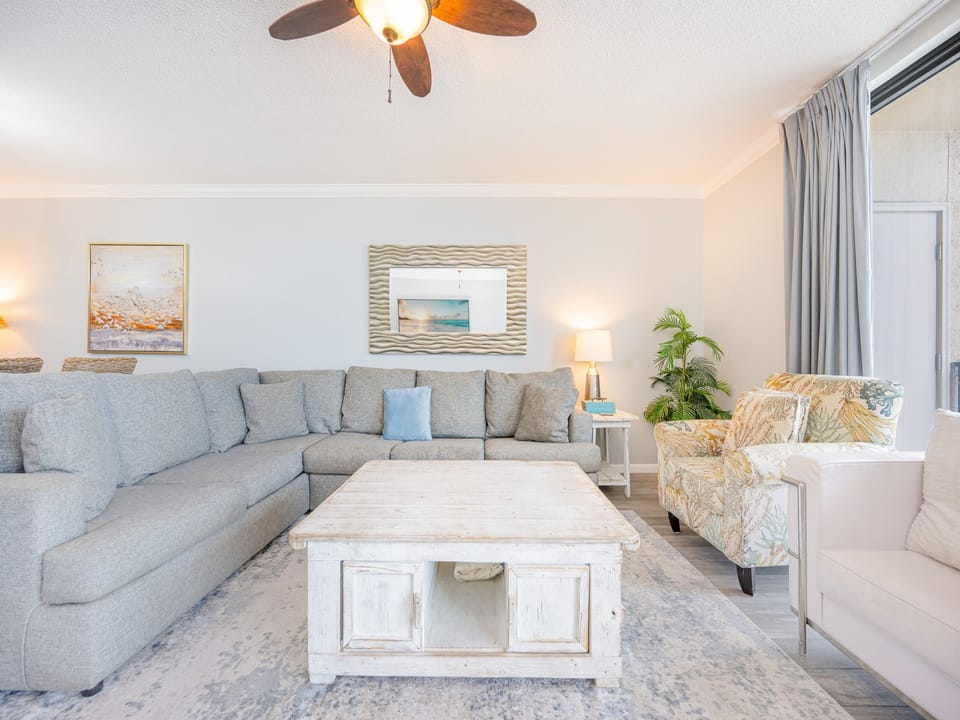 Plush seating invites you to unwind in the living room while gentle ceiling fan breezes circulate the space