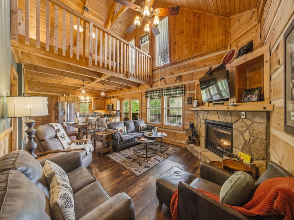 Cozy up by the stone fireplace in this stunning log cabin living room, where rustic charm meets modern comfort.