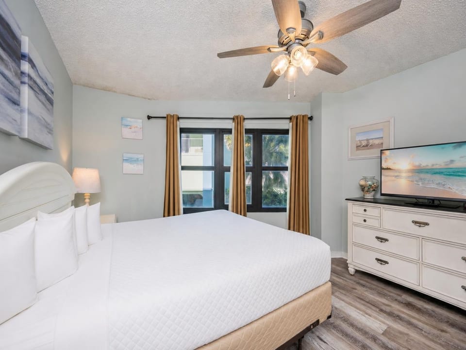Soft light fills the master suite with a king bed as you unwind and watch a sunset on the TV screen