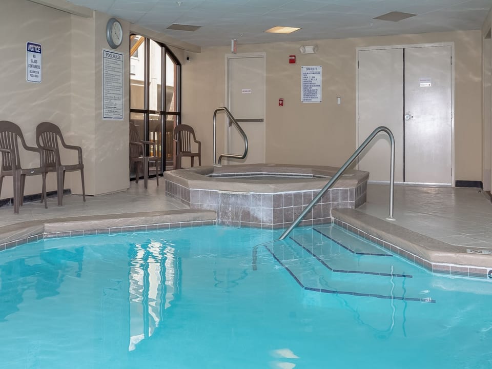 Relax in the inviting indoor pool area featuring a hot tub and comfortable seating for a perfect retreat