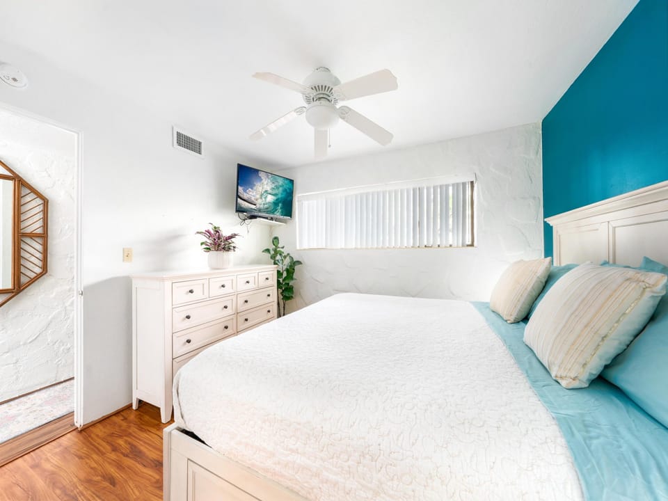Wake up refreshed in your bright bedroom with ocean-themed decor, ceiling fan, and TV for cozy evenings.