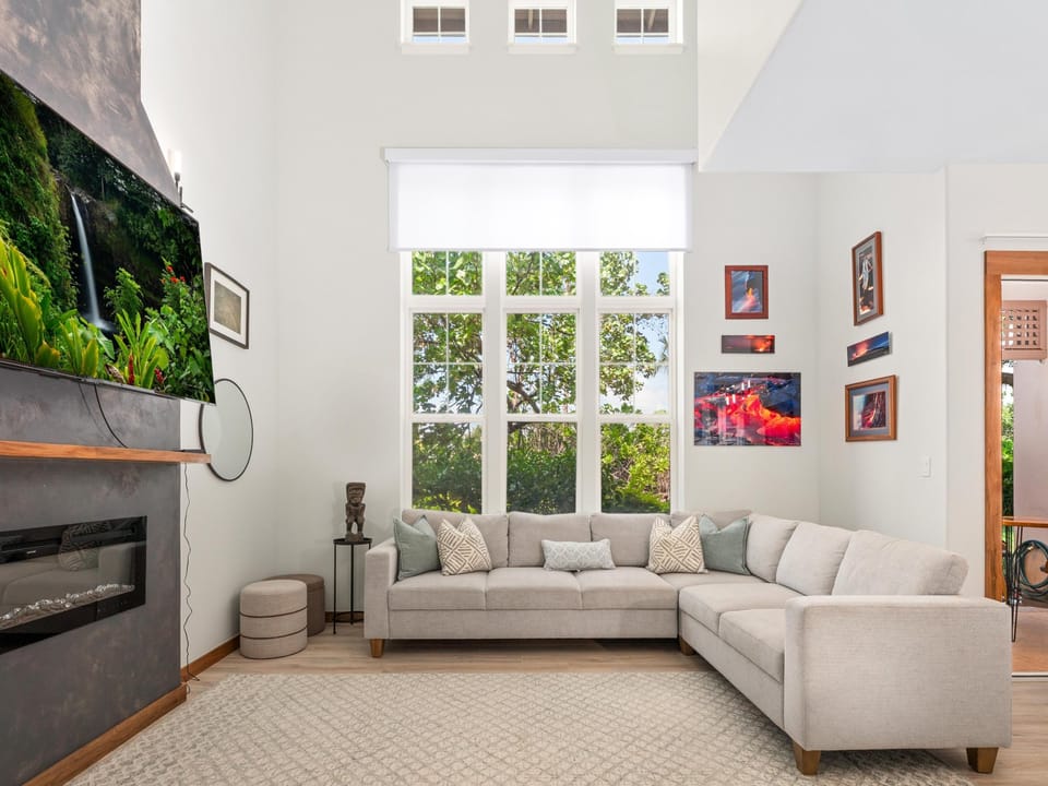 Relax on plush sectional seating while enjoying your favorite shows on the large TV in this bright, art-filled living space.