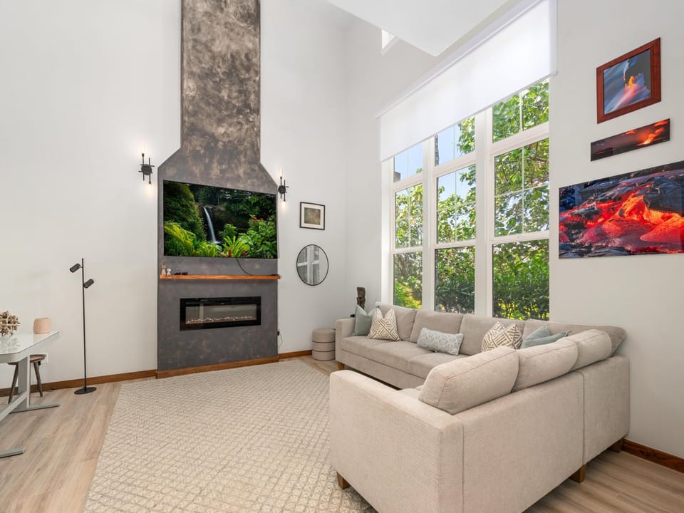 Unwind in your spacious living room featuring soaring ceilings, cozy fireplace, and plush sectional sofa perfect for movie nights.