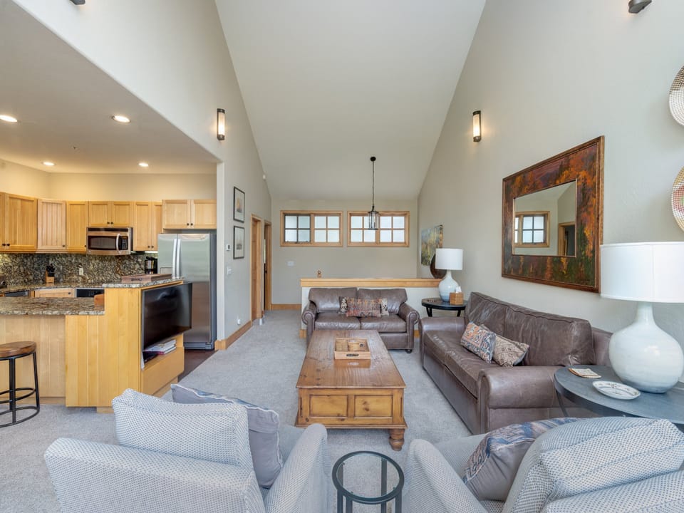 Settle into this spacious living area where vaulted ceilings and natural light create an airy retreat. Your fully equipped kitchen flows into the cozy lounge, perfect for unwinding after a day of adventure.