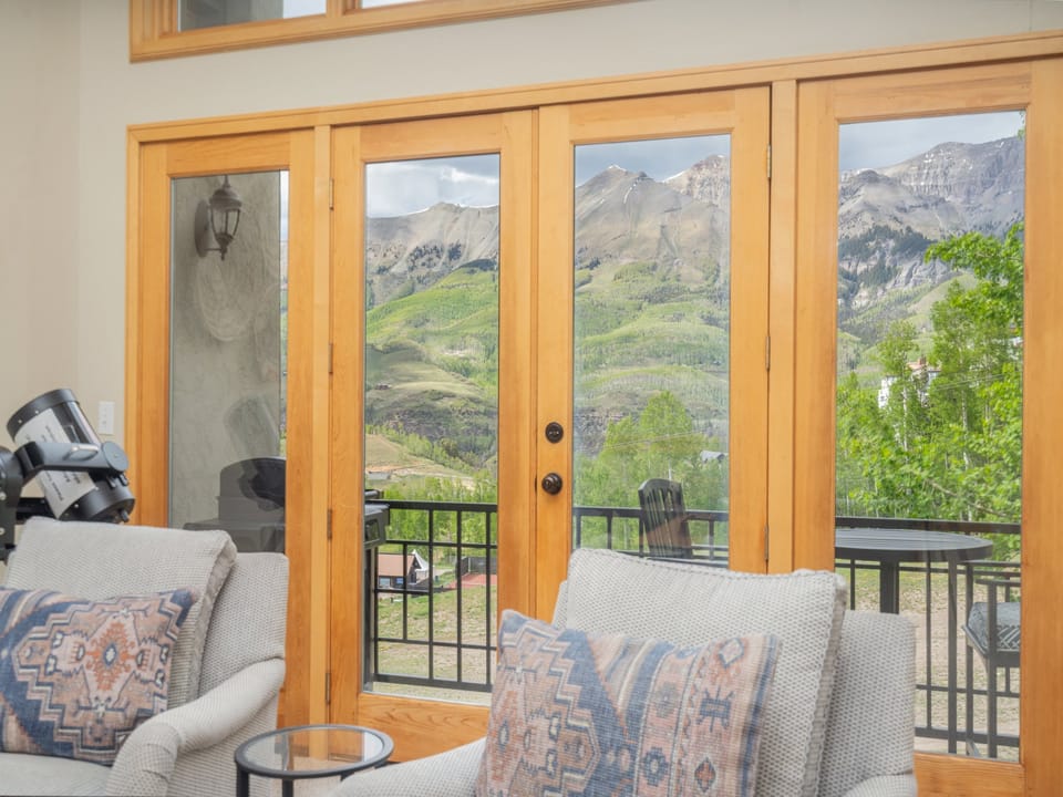 Step through French doors to your private balcony, where layered mountain peaks and green valleys stretch before you, inviting quiet mornings and peaceful evenings in nature's grand theater.