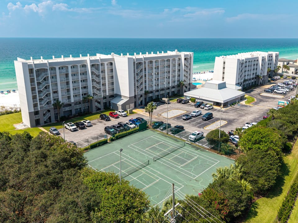 Beachfront property featuring tennis courts, pool, and direct access to pristine white sand beaches along the emerald coast.