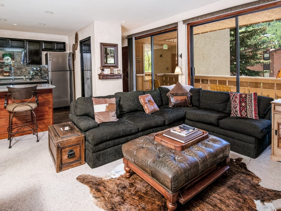 Settle into your inviting living space where a plush sectional beckons you to unwind after mountain adventures, while the open kitchen and private balcony add to your home-away-from-home comfort.