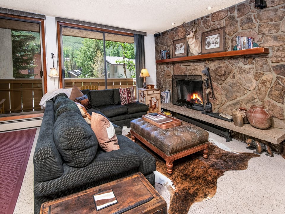 Curl up on the plush sectional and warm yourself by the crackling stone fireplace while gazing at mountain views through floor-to-ceiling windows—your perfect après-ski retreat.