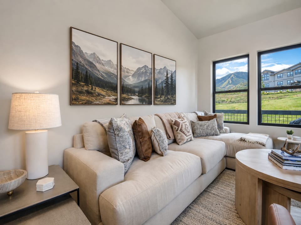 Sink into the plush sofa and let your gaze wander to stunning mountain views framed by large windows, where nature becomes your daily backdrop.