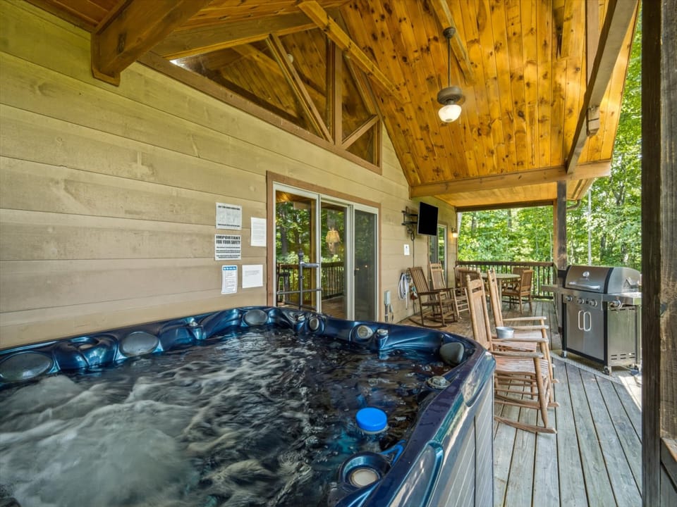 Sink into your private hot tub under the cathedral ceiling, then relax in rocking chairs with forest views all around. Fire up the grill and enjoy your evening outdoors.