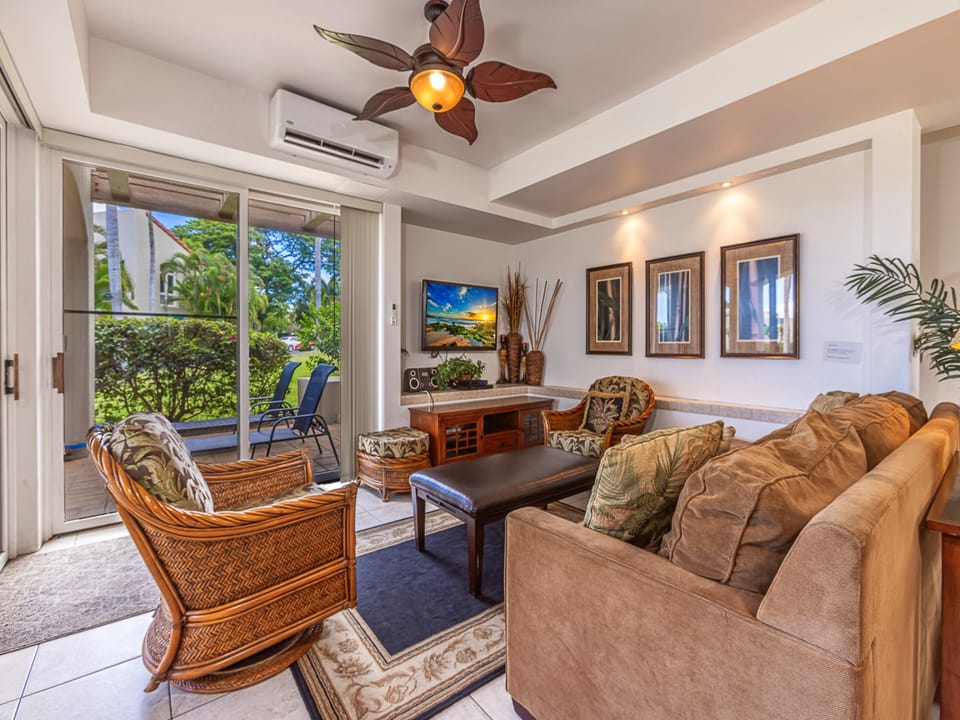Sink into plush seating in your tropical living room, where island breezes drift through open patio doors and warm sunshine invites you to unwind in complete comfort.