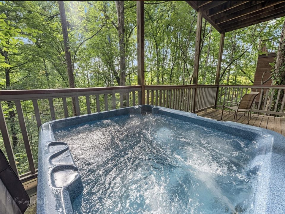 Soak in the bubbling hot tub on your private deck, surrounded by lush forest and peaceful mountain views—your perfect escape for ultimate relaxation.