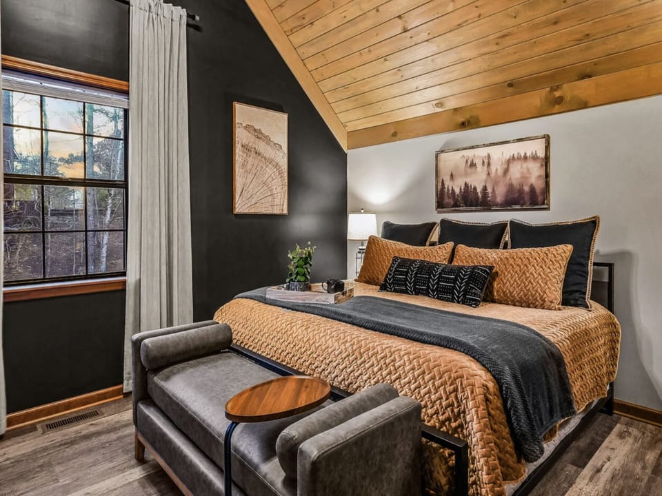 Sink into plush bedding and warm wood tones in your private bedroom retreat, where natural light and cozy textures invite restful mornings and peaceful nights.