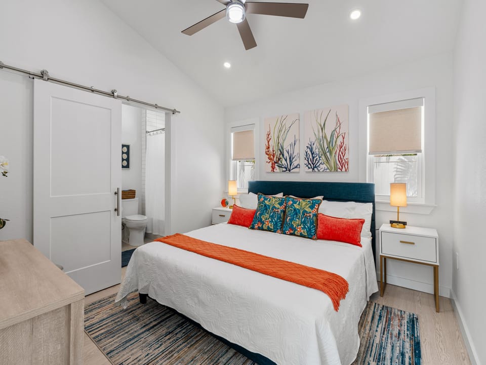 Unwind in your coastal-inspired bedroom, complete with a plush bed, charming decor, and your own ensuite bathroom behind the elegant barn door.