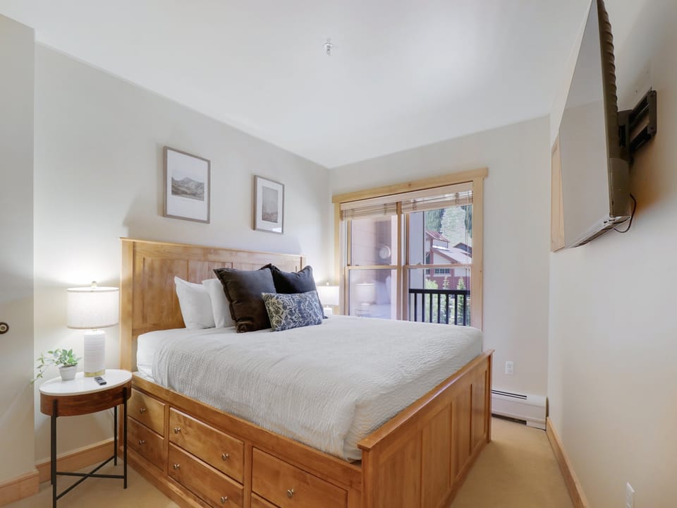 Step into your serene bedroom retreat with soft linens, warm wood furnishings, and a private balcony—where mountain air and peaceful mornings await.