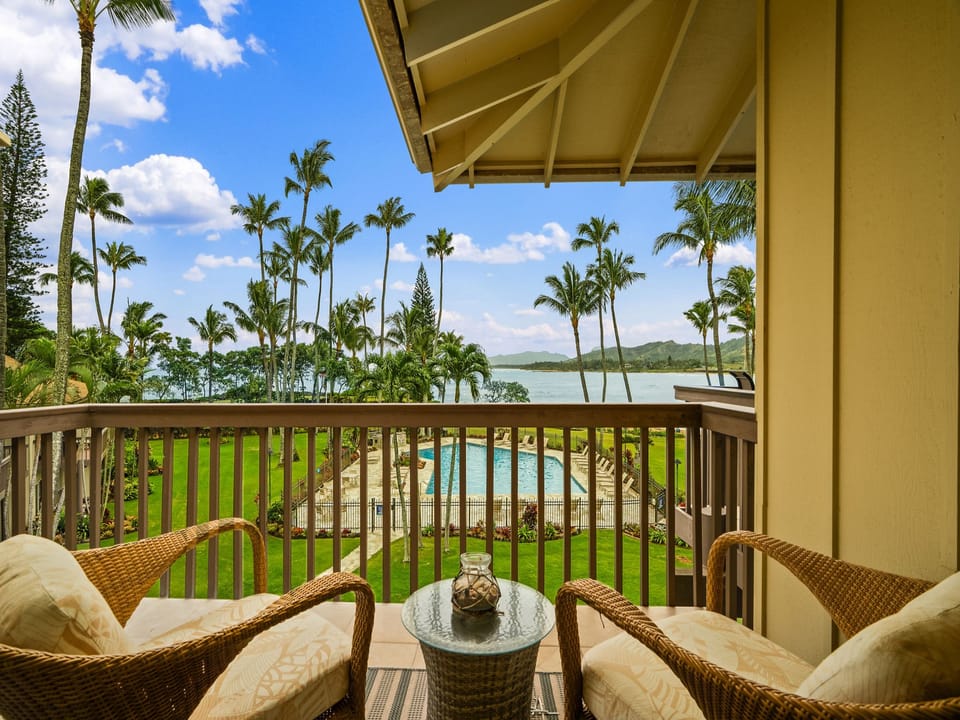 Relax on your private lanai with plush seating and sweeping views of swaying palms, lush lawns, and sparkling pool waters stretching toward serene coastal horizons.
