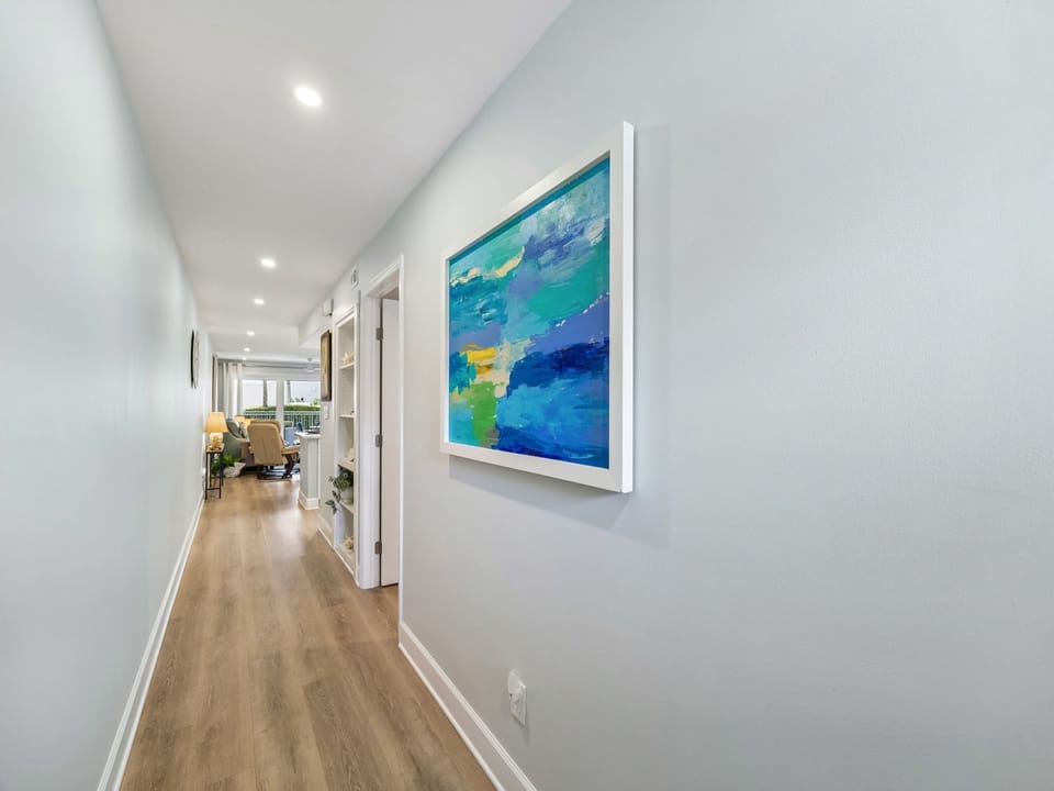Bright, thoughtfully designed hallway with coastal-inspired artwork guides you from one inviting space to another, setting a calm, welcoming tone throughout your stay.