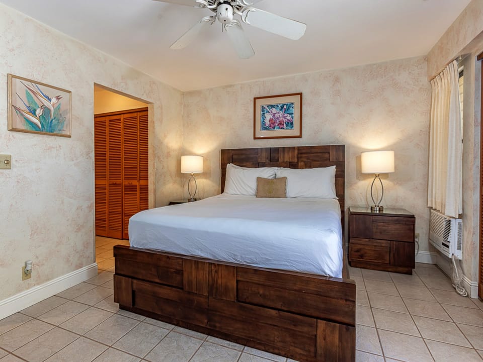 Your serene retreat with a plush king bed, tropical artwork, and warm lighting that creates the perfect ambiance for unwinding after a day of island adventures.