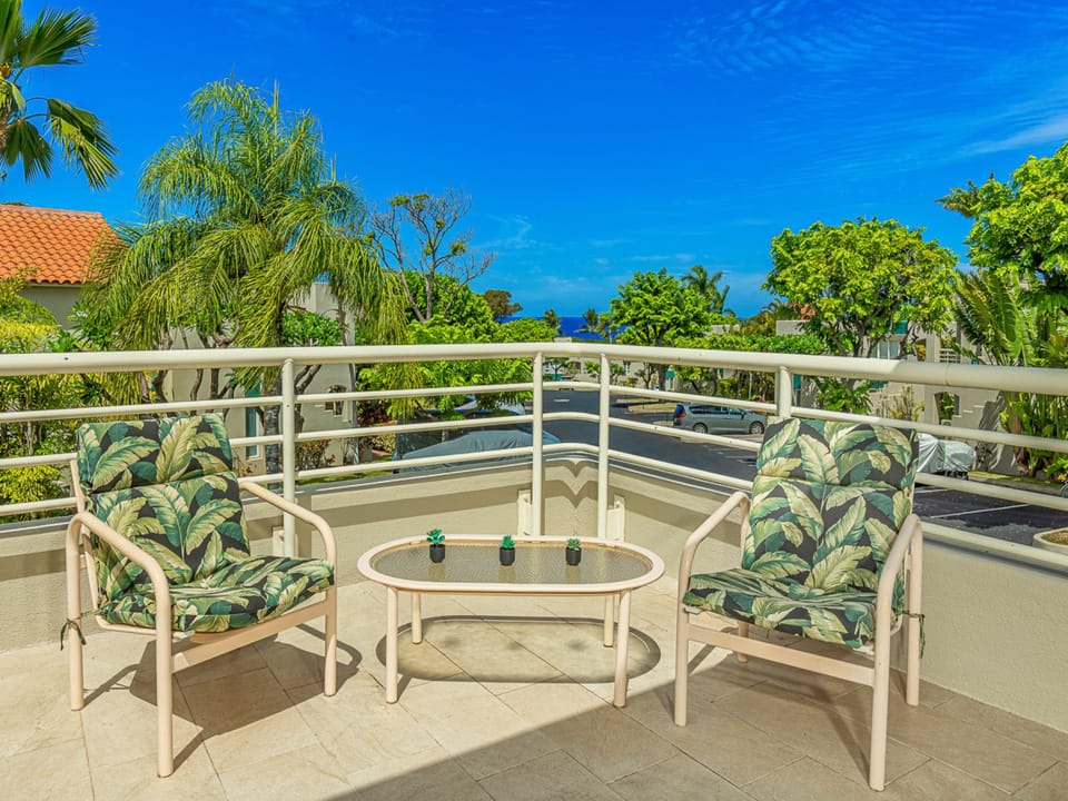Soak in the tropical views from your private balcony, where lush palms frame glimpses of sparkling blue water. This cozy outdoor retreat invites you to unwind with morning coffee or evening relaxation.